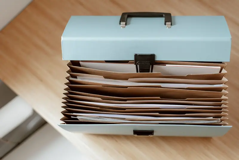 Trieur à soufflets rempli de documents classés, sur un bureau