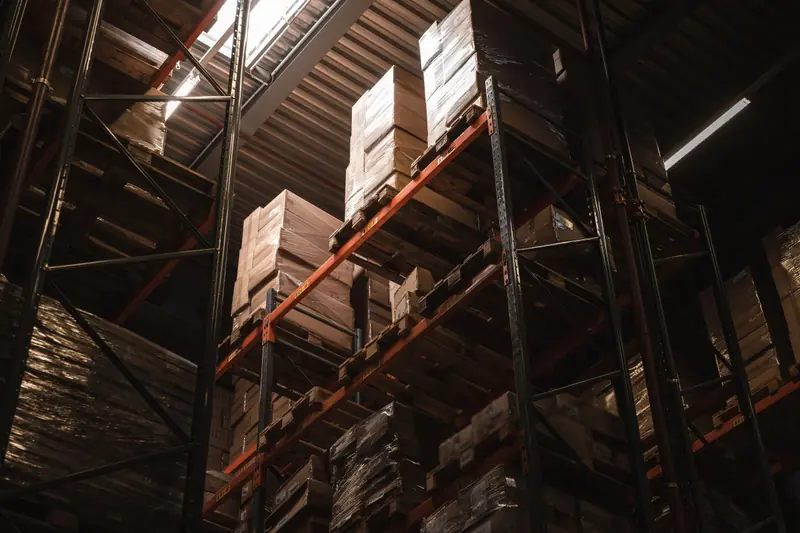 Rayonnages d'entrepôt chargés de palettes et de cartons, vus en contre-plongée